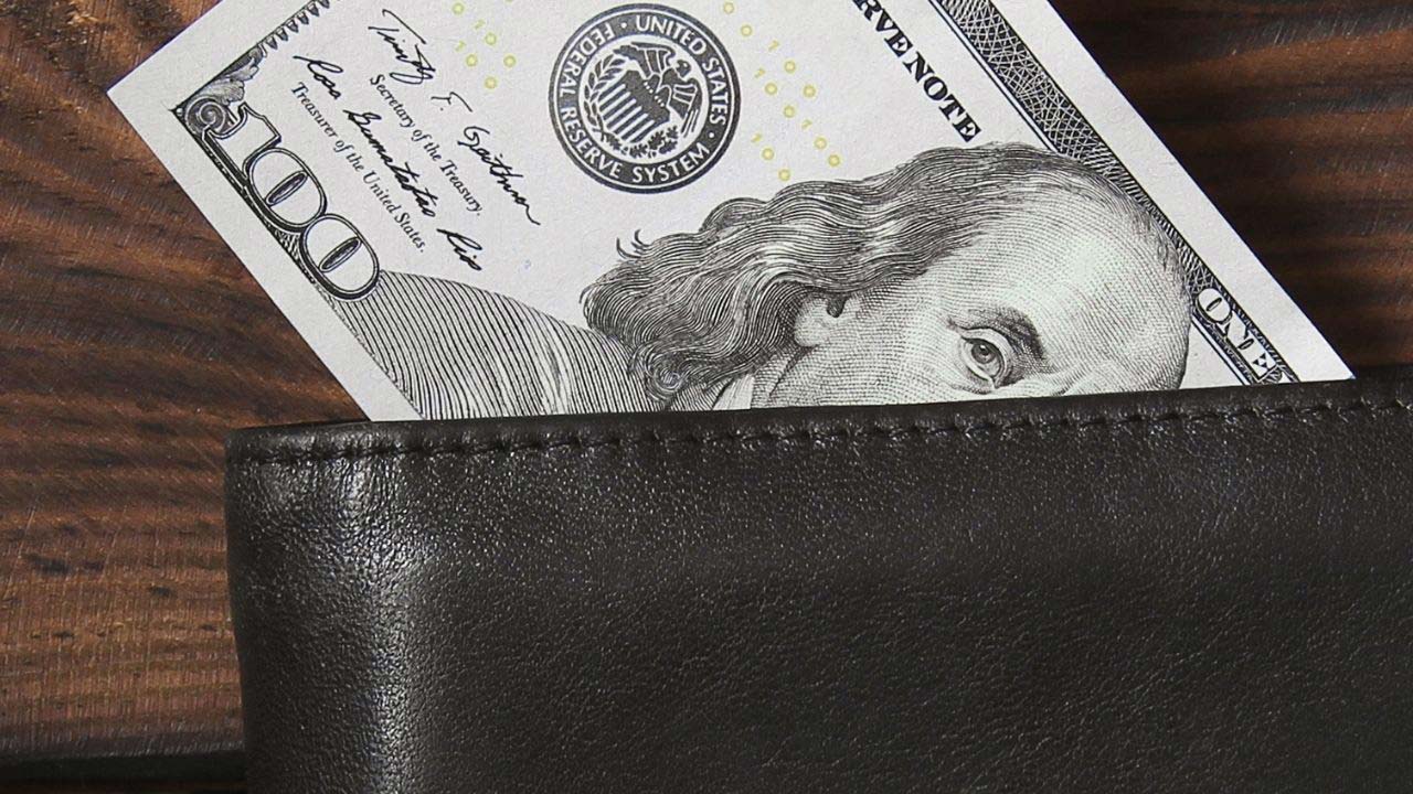 $100 bill sticking out of a wallet