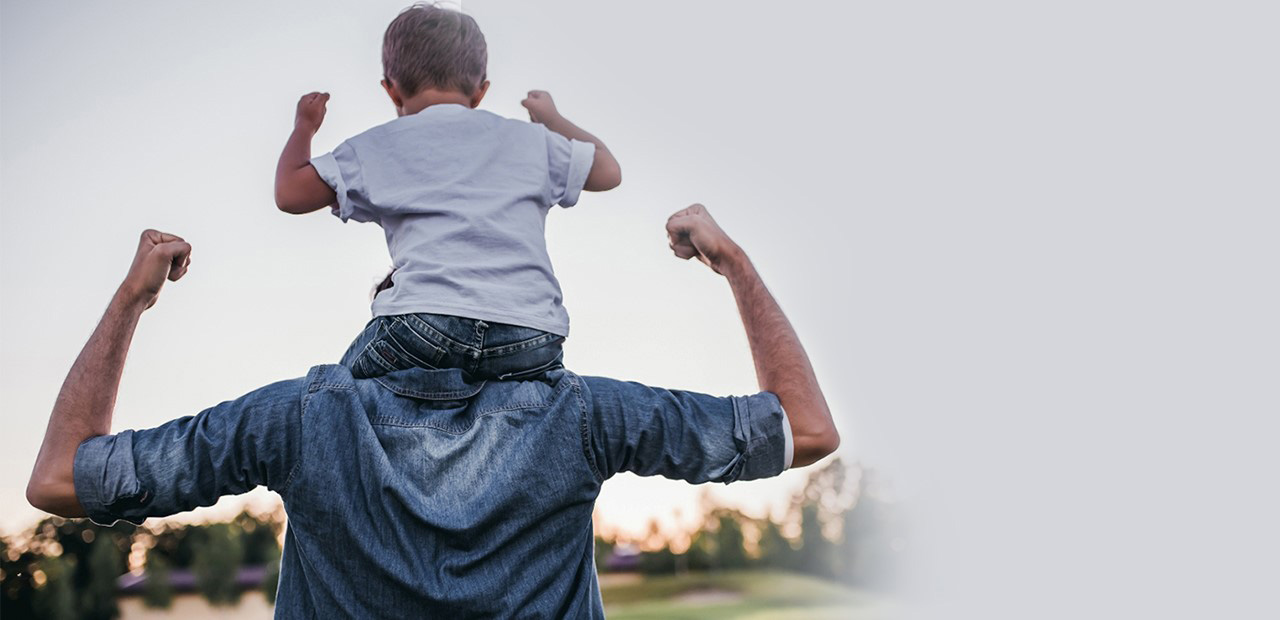 Little boy sitting on his father shoulders