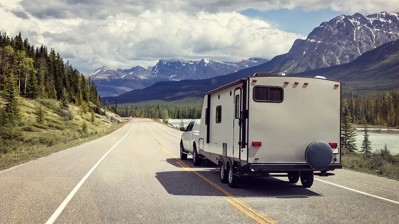 Pickup truck with camper on open road